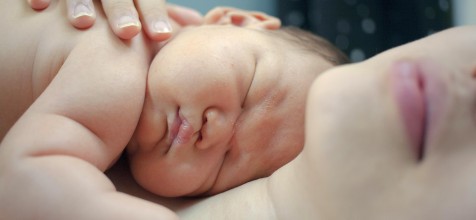 Baby liegt in den Armen der Mutter